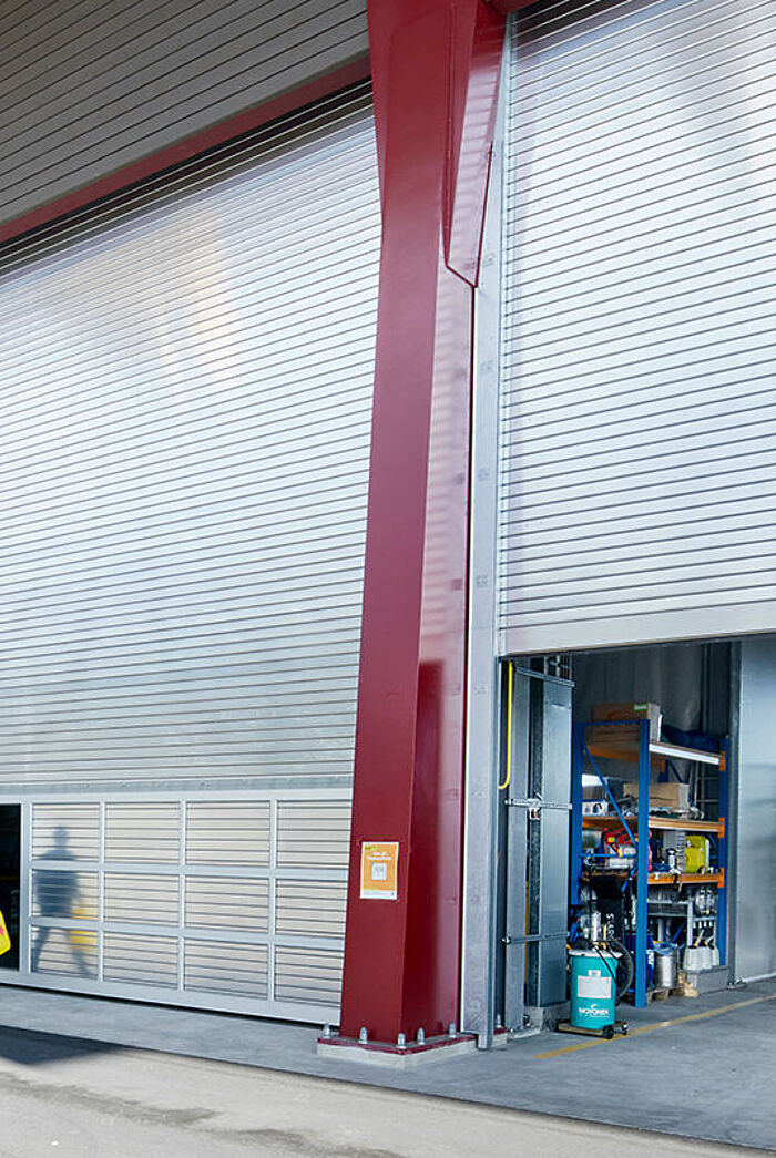 Ein grosses Industrierolltor mit Schlupftür beim REAL Recyclingcenter Emmenbrücke