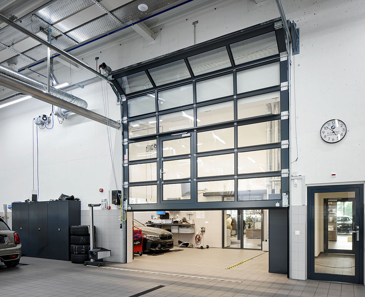 In der Werkstatt der Garage Emmenegger AG sind vollverglaste Sektionaltore mit verschleissarmen Rohrwellen-Systemen verbaut. Die 2-fach-Isolierverglasung ESG (Echtglas) wertet die Tore zusätzlich auf.