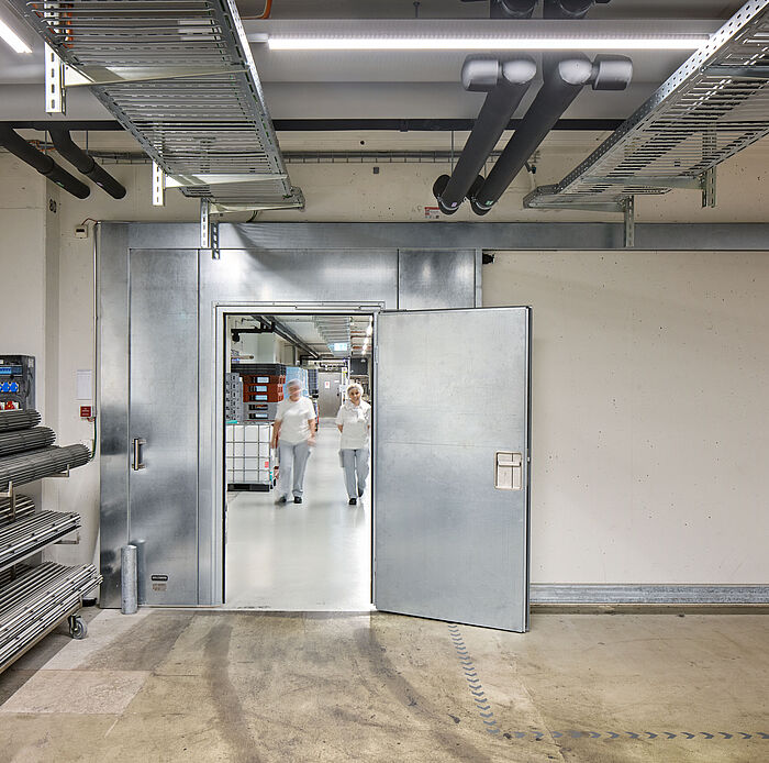 Das Brandschutzschiebetor EI30 mit integrierter Fluchttür von Wolfisberg Tor-Technik in den Innenräumen von HUG AG, Malters.
